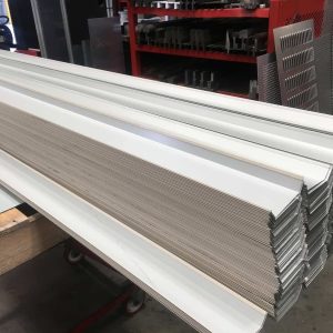 Stacked metal profiles after bending process, showcasing precision sheet metal fabrication and forming in a manufacturing facility